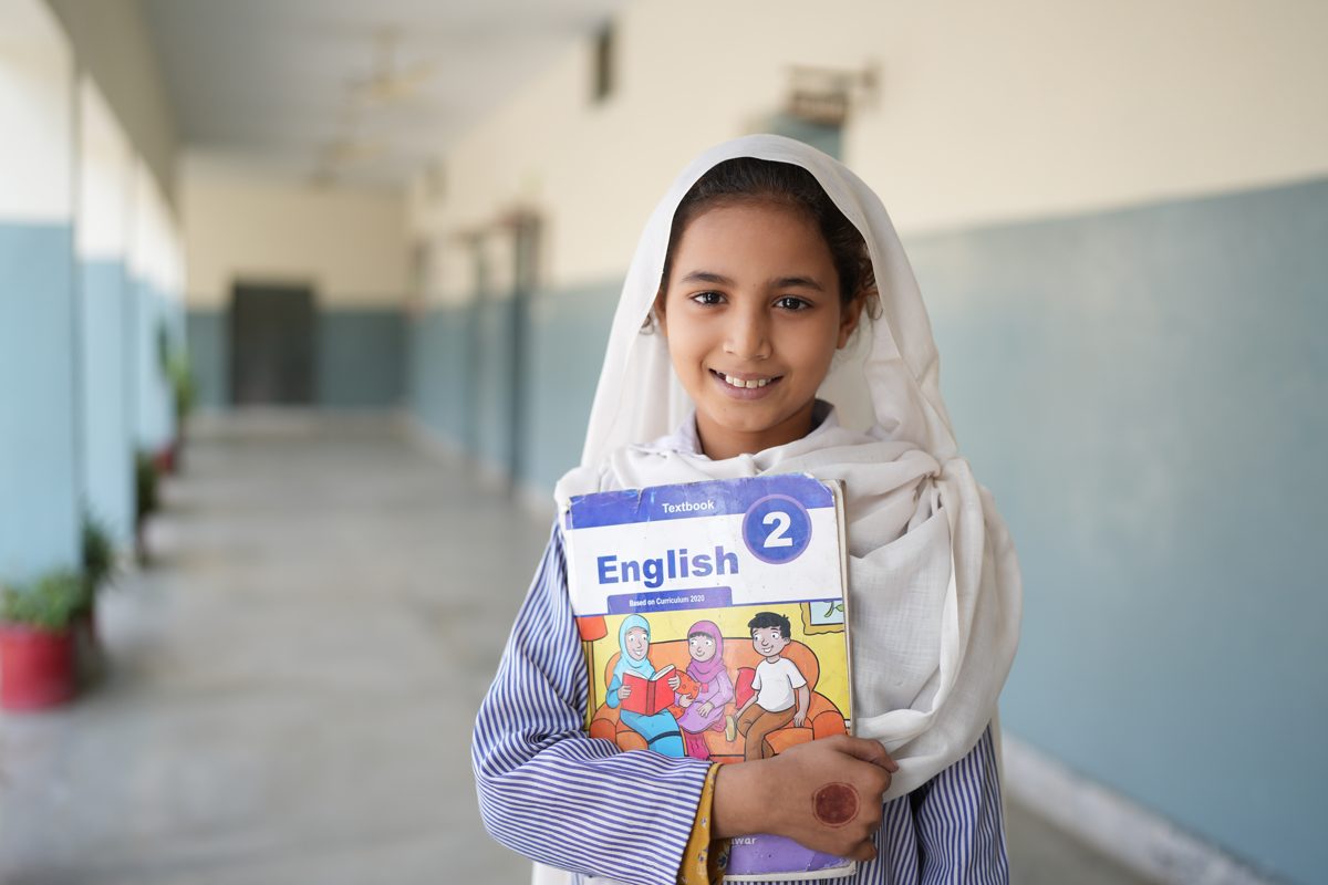 A girl holding her English book in an HDF classroom