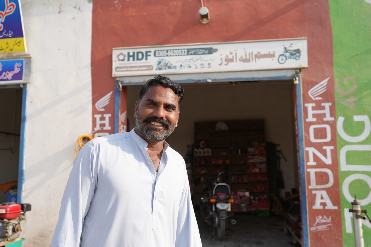 A man at his motorcycle repair workshop supported by HDF