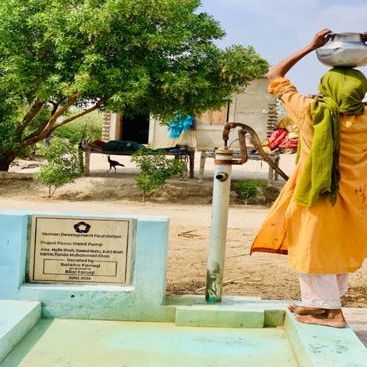 A girl at a hand pump